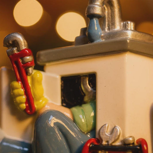 Close-up of a figurine holding a wrench with a blurred background