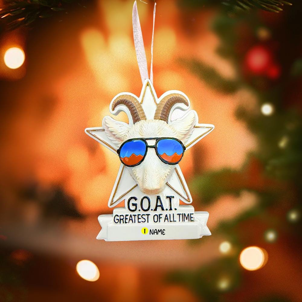 Decorative ornament with goat wearing sunglasses and 'G.O.A.T.' text against a Christmas tree background.