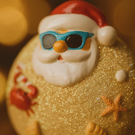 Santa Claus figurine with sunglasses on a beach-themed background
