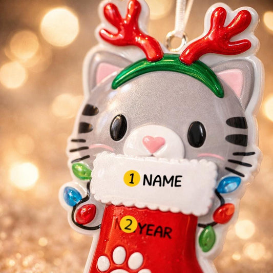 Christmas ornament of a cat with reindeer antlers and Santa hat on a blurred lights background