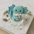 Load image into Gallery viewer, Blue cartoon-like creature with leaf accents on a decorative surface with greenery and red berries.
