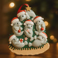 Load image into Gallery viewer, Decorative Christmas ornament with seals wearing Santa hats and holding Christmas items on a blurred festive background.
