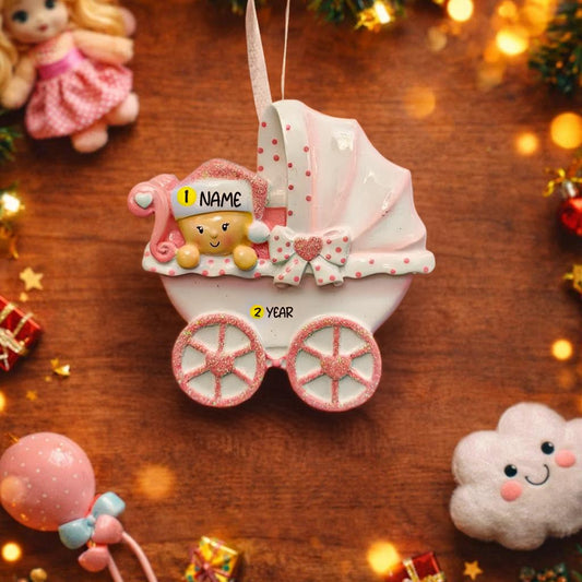 Personalized baby girl Christmas ornament featuring a soft pink stroller with glitter details and a smiling baby wearing a pink nightcap. Custom name appears on the top and year on the bottom, making it a perfect Baby’s First Christmas keepsake. This pink resin holiday ornament is ideal for newborn girls, baby shower gifts, and celebrating a special first Christmas memory.
