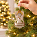 Load image into Gallery viewer, Decorative angel ornament being hung on a Christmas tree with blurred lights in the background
