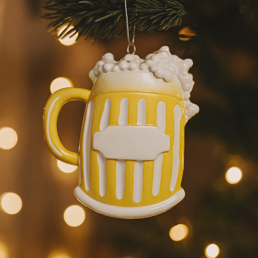 Yellow mug ornament with white foam on a blurred Christmas tree background