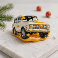 Load image into Gallery viewer, Toy car with yellow accents on a white surface with Christmas decorations
