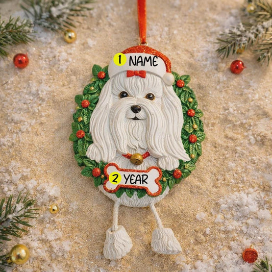 Decorative Christmas ornament with a white Maltese dog in a wreath on a textured surface with holiday decorations.
