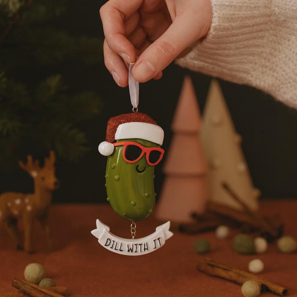 Decorative pickle ornament with a Santa hat and sunglasses, held by a hand against a festive background.