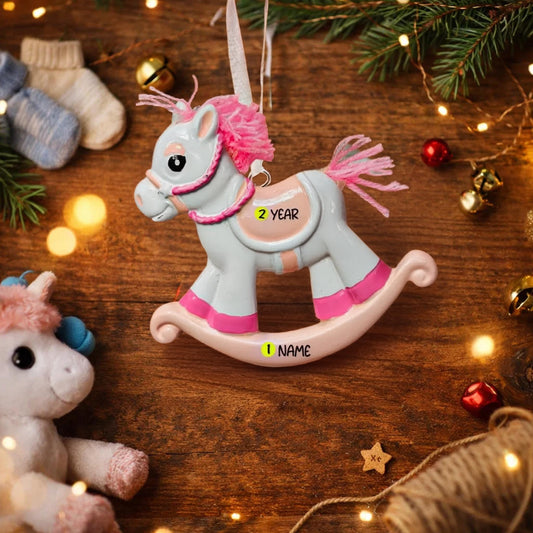 Decorative rocking horse ornament with personalized details on a wooden surface with festive decorations.