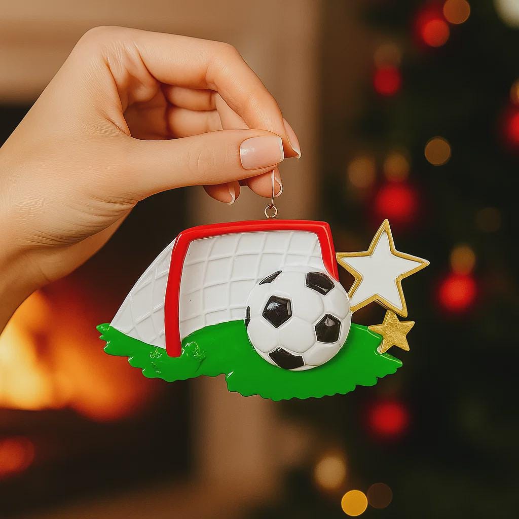 Personalized soccer ornament featuring a detailed goal and ball design with a glossy finish and raised 3D details. The ornament includes one custom name and year displayed on the front. Styled with festive lighting and greenery, this sports themed ornament is perfect for soccer lovers, players, and coaches. Designed with a 3D front and flat back, lightweight and easy to hang on a Christmas tree or display year round.
