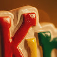 Load image into Gallery viewer, Colorful letters spelling 'Knoq' on a blurred background

