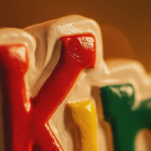 Colorful letters spelling 'Knoq' on a blurred background