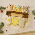 Load image into Gallery viewer, Decorative set with baby-themed items including a teddy bear, elephant, and baby clothes on a shelf.
