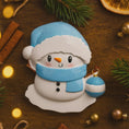 Load image into Gallery viewer, Personalized Snowman Baby Christmas Ornament featuring a cheerful snowman with blue glitter hat and scarf, holding a sparkling ornament. This design has a raised 3D front with textured details, dimensional elements, and vibrant winter colors. The child’s name is placed on the scarf and the year is added below. A perfect keepsake for baby’s first Christmas, newborn gift, winter holiday decoration, and meaningful family tree memory ornament.

