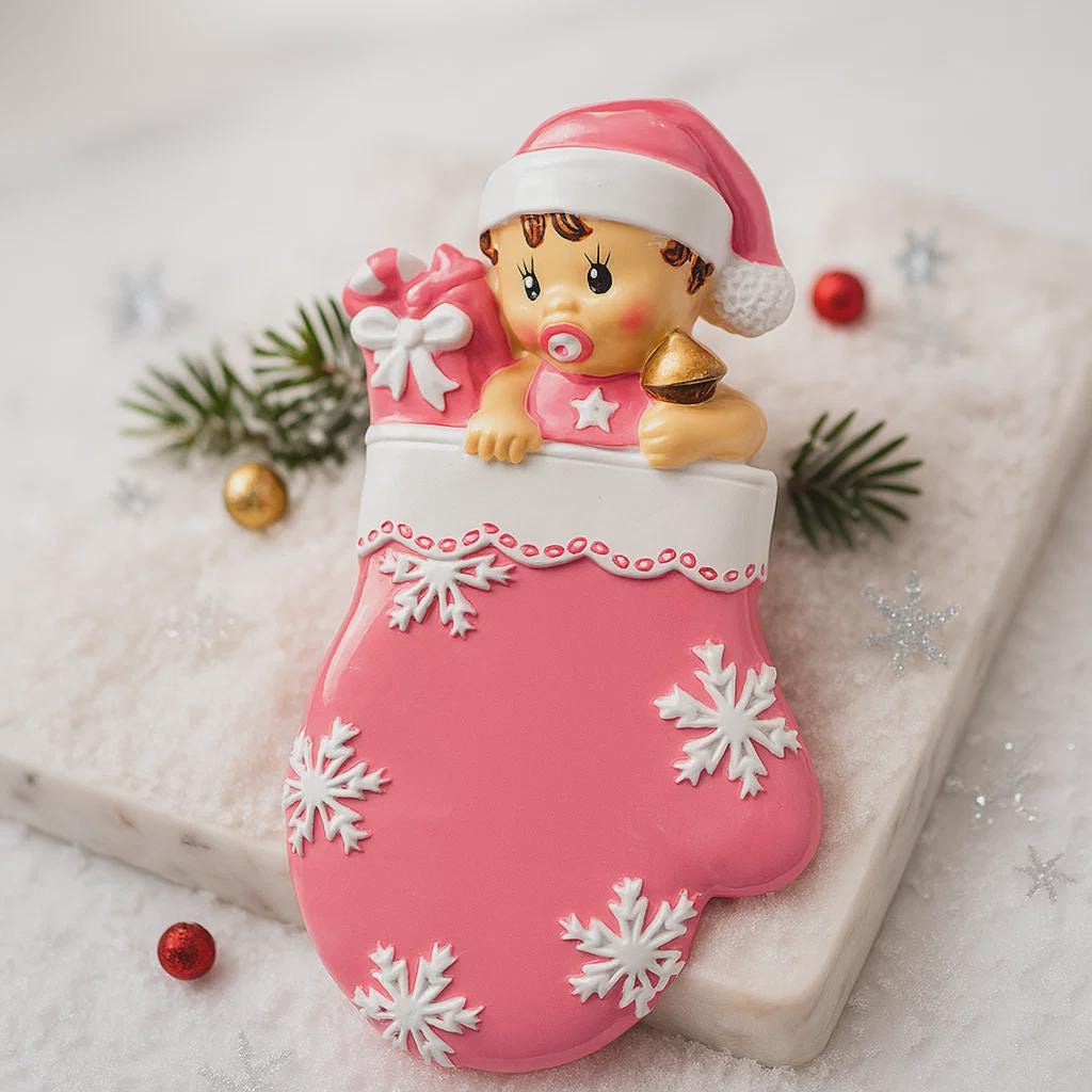 Personalized Baby Girl Christmas Ornament featuring a sweet baby in a pink stocking with raised 3D front details and textured snowflake accents. The name is added on the hat and the year on the stocking, creating a meaningful newborn keepsake. Soft pink tones, holiday elements, and dimensional design make it perfect for baby’s first Christmas, baby girl gift, and special family memory ornament for the tree.