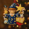 Load image into Gallery viewer, A cute blue-robed wizard boy Christmas ornament featuring a magic wand, star, open book and owl, perfect for kids. Personalized with name and year. Ideal holiday tree decoration for little wizard fans and magical Christmas gifts.
