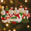Load image into Gallery viewer, Personalized snowman family ornament with name tags on a Christmas tree.
