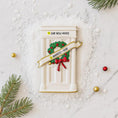Load image into Gallery viewer, Decorative door with wreath and text on a snowy background
