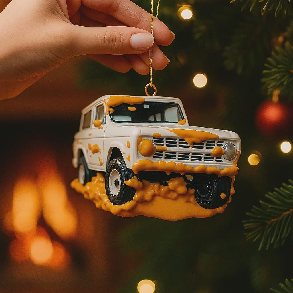 Decorative ornament shaped like a vintage SUV on a Christmas tree with lights in the background