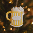 Load image into Gallery viewer, Yellow mug ornament with white foam on a Christmas tree
