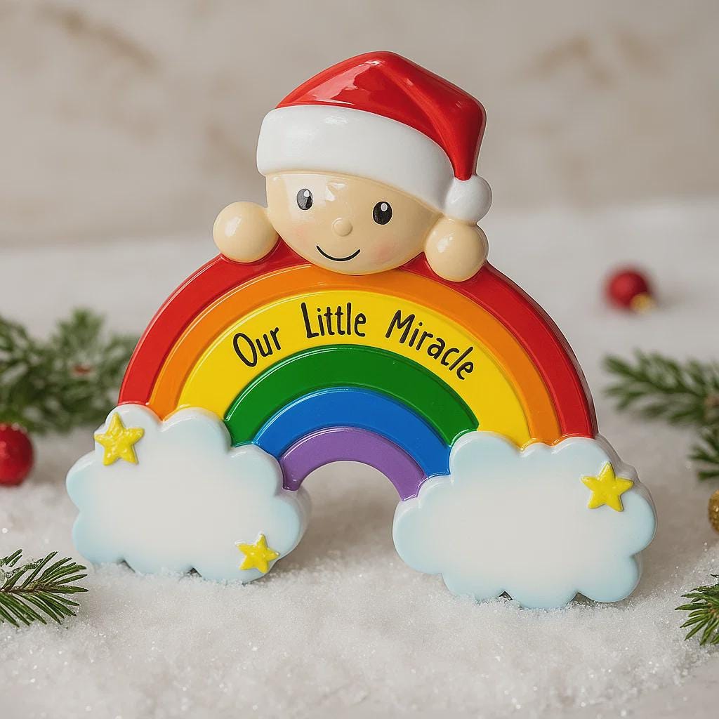 Decorative ornament with rainbow, clouds, and 'Our Little Miracle' text, featuring a Santa hat.