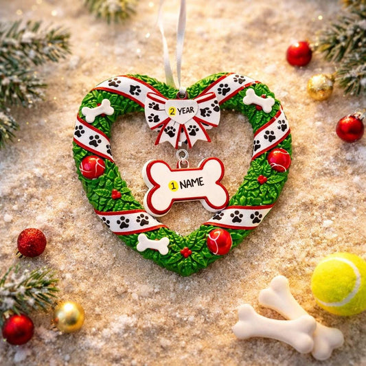 Heart-shaped Christmas wreath ornament with bone and paw print design on a textured surface with festive decorations.