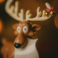 Load image into Gallery viewer, Decorative reindeer figurine with a bow and jingle bells on a warm-toned background
