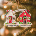 Load image into Gallery viewer, Decorative Christmas ornament with two houses neighbor and personalized text on a blurred Christmas tree background.
