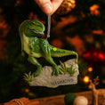 Load image into Gallery viewer, Realistic dinosaur themed Christmas ornament featuring a detailed T-Rex design with vibrant green tones and a playful yet bold appearance. Styled in a warm holiday setting, this ornament is designed to be personalized and makes a fun keepsake for kids who love dinosaurs and adventure themed decorations
