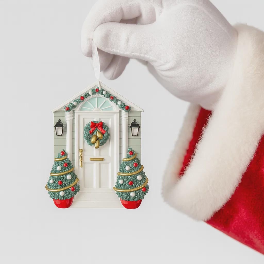 Decorative Christmas house ornament held by a gloved hand with a Santa Claus outfit.
