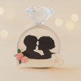Load image into Gallery viewer, Silhouette of a couple inside a diamond ring with flowers on a beige background

