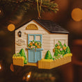 Load image into Gallery viewer, Decorative ornament of a small house with 'She Shed' sign on a tree.
