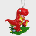 Load image into Gallery viewer, Colorful dinosaur themed Christmas ornament designed for kids, featuring a playful character and bright cheerful tones. Set in a cozy holiday scene, this ornament brings fun and imagination to children’s Christmas tree decor. Designed to be personalized, making it a special keepsake for kids who love dinosaurs and playful holiday decorations.

