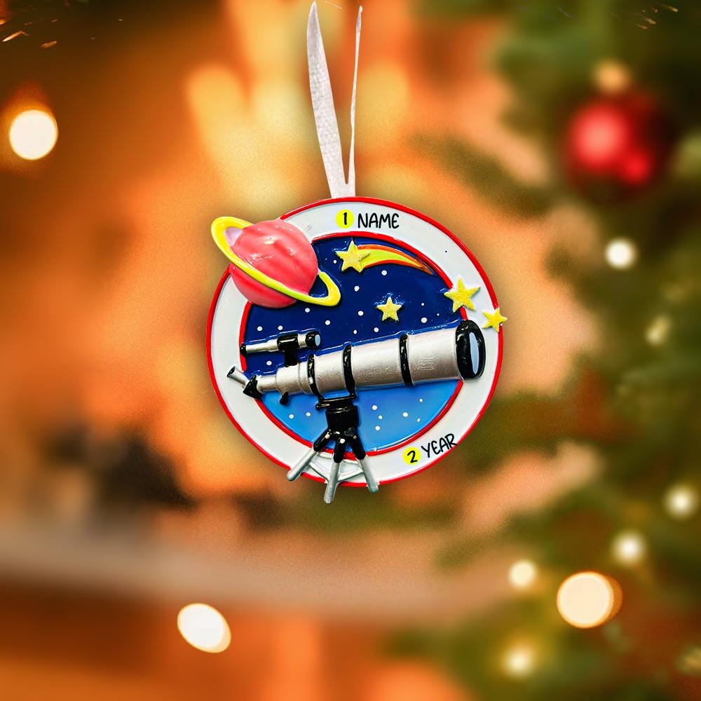 Decorative ornament with a telescope and space-themed design on a Christmas tree.