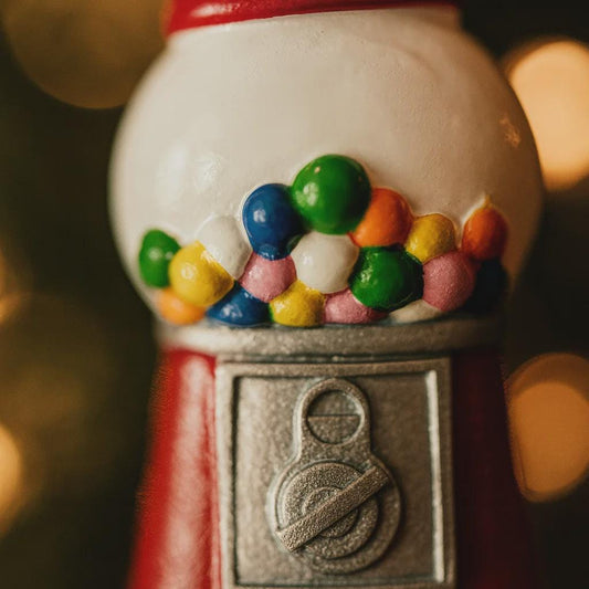 Gumball machine with colorful gumballs against a blurred background