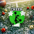 Load image into Gallery viewer, Personalized cheerleading Christmas ornament featuring a bright green glitter background with a cheer silhouette holding pom poms, bold CHEER title at the top, customizable name area on the lower banner, customizable year displayed on a star detail, and additional personalization space for school name or initials, glossy finish with raised 3D front elements and flat 2D back, white hanging ribbon, photographed on a snowy sports field themed holiday background with festive ornaments and winter greenery.
