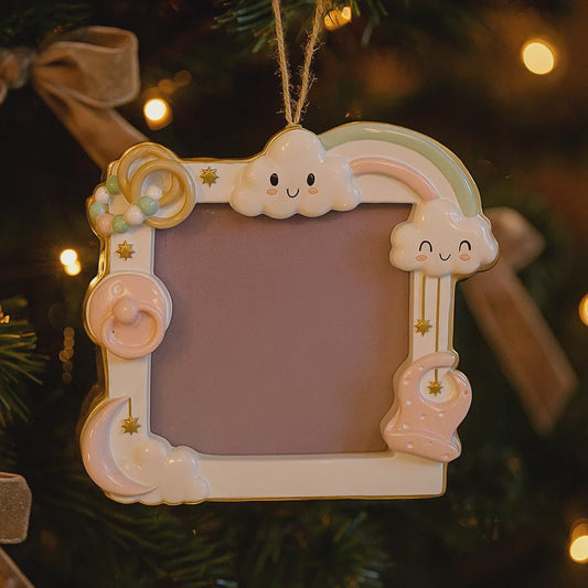 Decorative photo frame with cloud and rainbow design hanging on a Christmas tree.