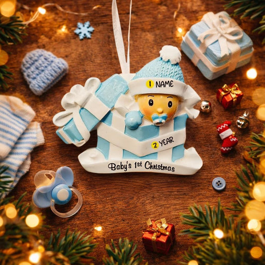 Personalized Baby Boy First Christmas Ornament featuring an adorable baby popping out of a blue gift box with a matching hat and pacifier. The name is displayed on the hat while the year is placed on the ribbon detail, with Baby’s 1st Christmas written along the base. Soft blue and white tones, raised 3D elements, and sweet holiday details make this a charming keepsake. Perfect for newborn boys, baby showers, and celebrating a baby’s very first Christmas season.