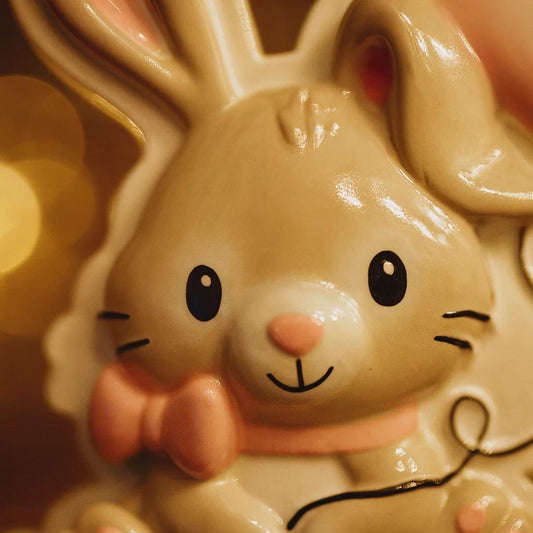 Close-up of a ceramic bunny with a bow tie against a blurred background
