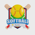 Load image into Gallery viewer, Personalized softball Christmas ornament featuring a yellow softball with stitched details and crossed bats design on a shield style background, customizable name area on the front banner and customizable year area on the softball, glossy finish with raised 3D front details and flat 2D back, white hanging ribbon, displayed on a snowy softball field themed holiday background with pine branches and festive decorations.
