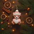 Load image into Gallery viewer, Personalized Pink Teddy Bear Christmas Ornament featuring a sweet baby bear wearing a cozy winter hat and holding a heart that can be customized with a name and year or Baby’s 1st Christmas. This adorable baby girl ornament is designed in soft pink tones, perfect for celebrating a newborn’s first holiday season. A heartwarming keepsake gift for new parents, baby showers, or a special Christmas memory that will be treasured for years to come.
