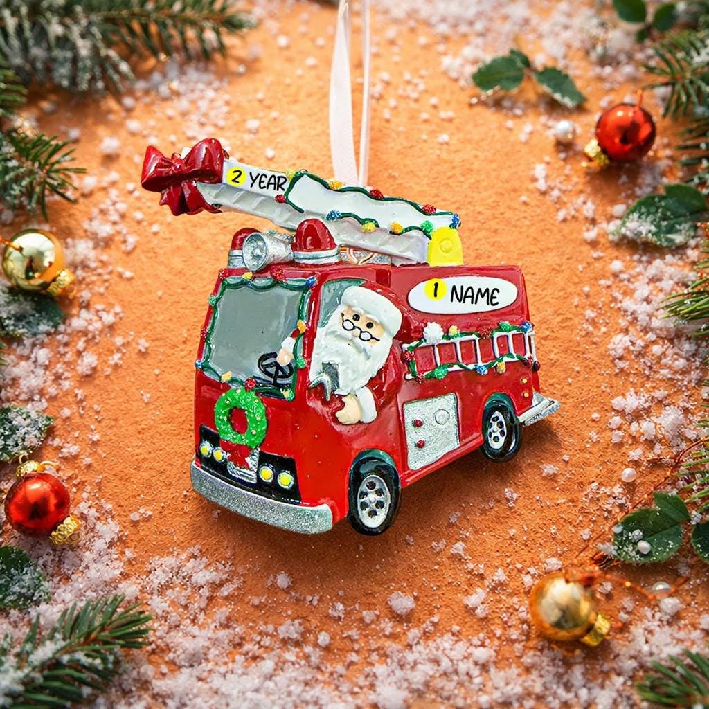 Christmas ornament of a red fire truck with Santa Claus driving, surrounded by festive decorations.