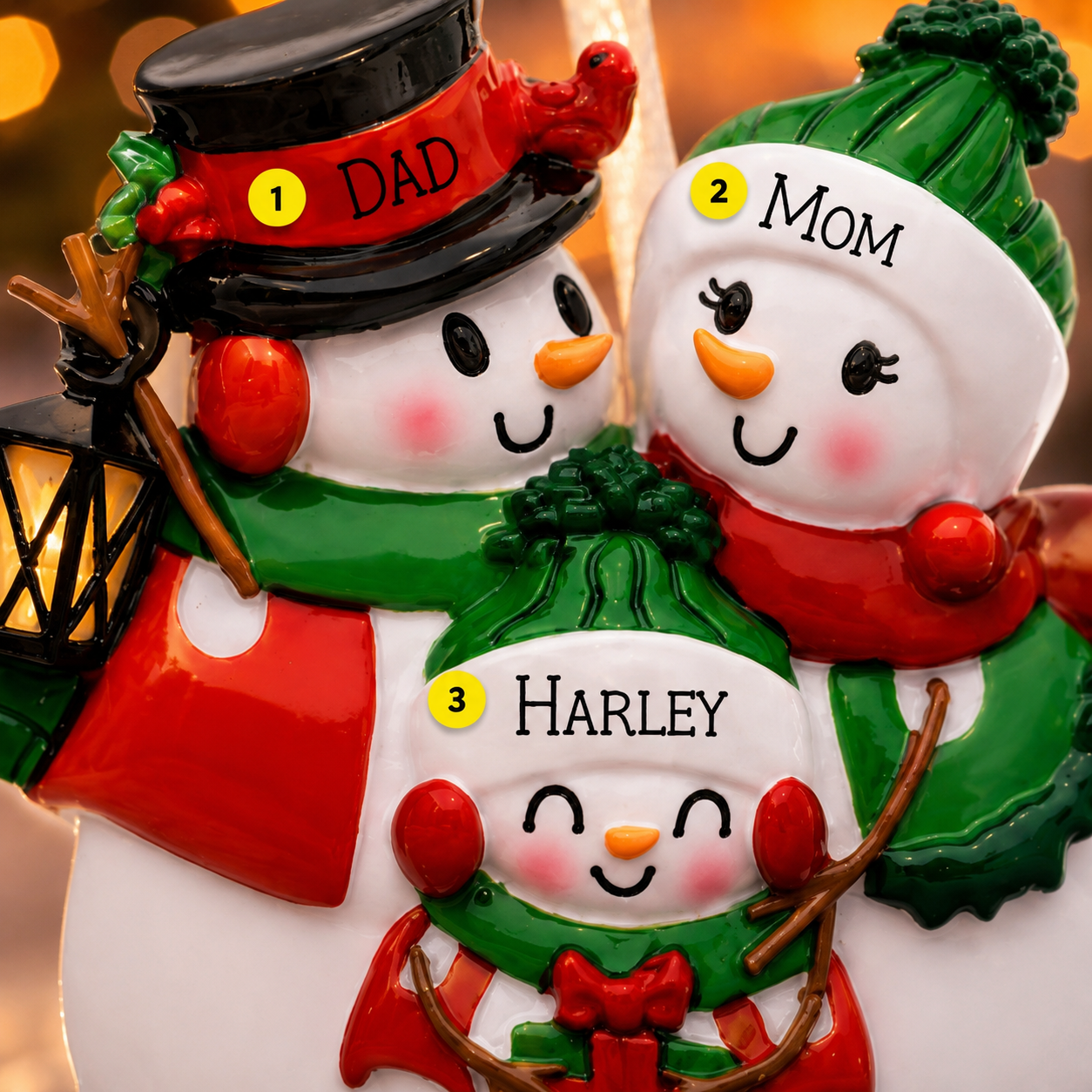 Decorative snowman family ornament with 'Dad', 'Mom', and 'Harley' on a blurred background.