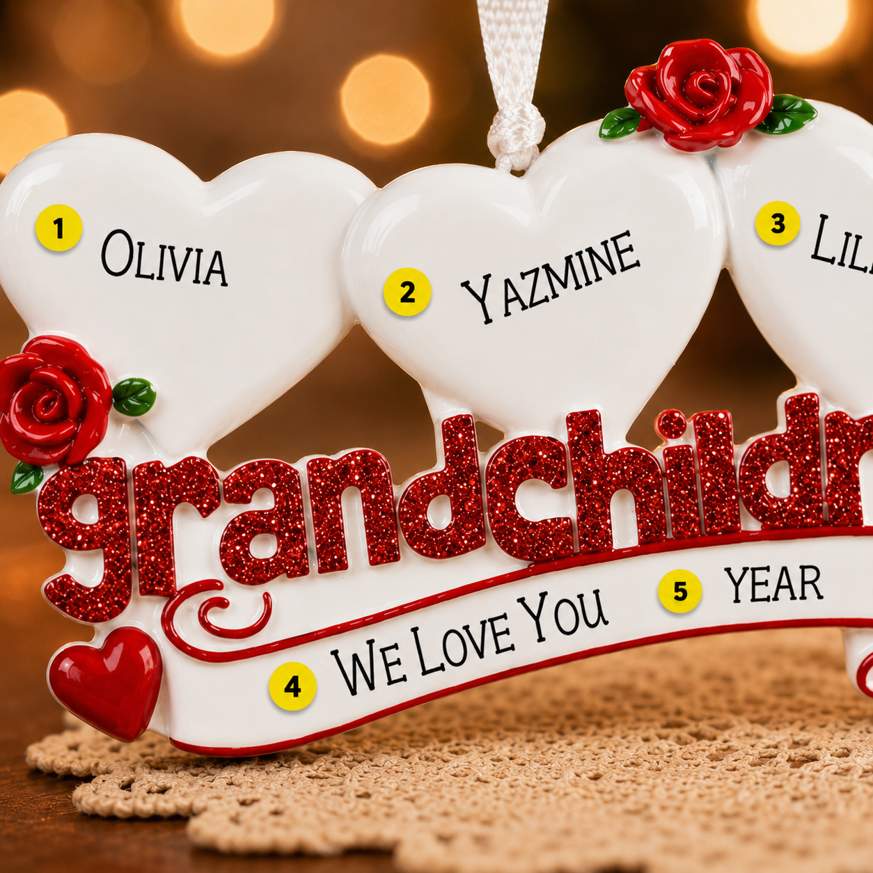 Decorative heart-shaped ornament with names and 'grandchildren' text on a blurred background