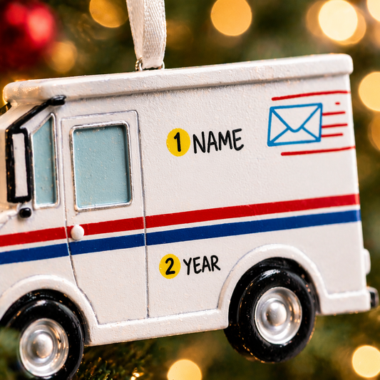 Decorative mail truck ornament with customizable text on a blurred Christmas tree background