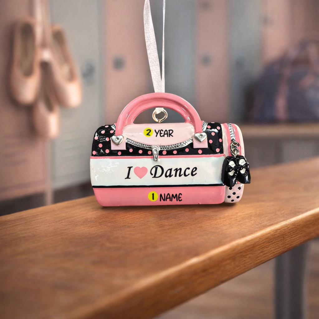 Pink and black handbag-shaped ornament with 'I ❤️ Dance' text on a wooden surface.