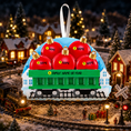 Load image into Gallery viewer, Decorative train ornament with red apples on a snowy village background
