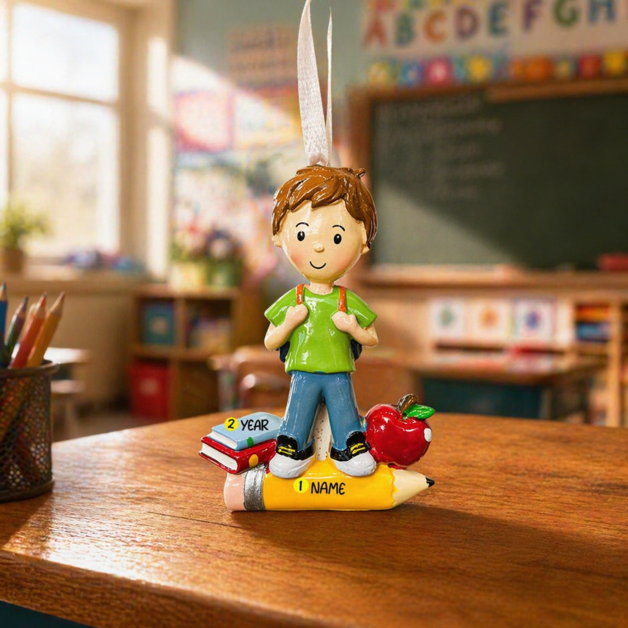 ornament of a child with a pencil on a desk in a classroom setting
