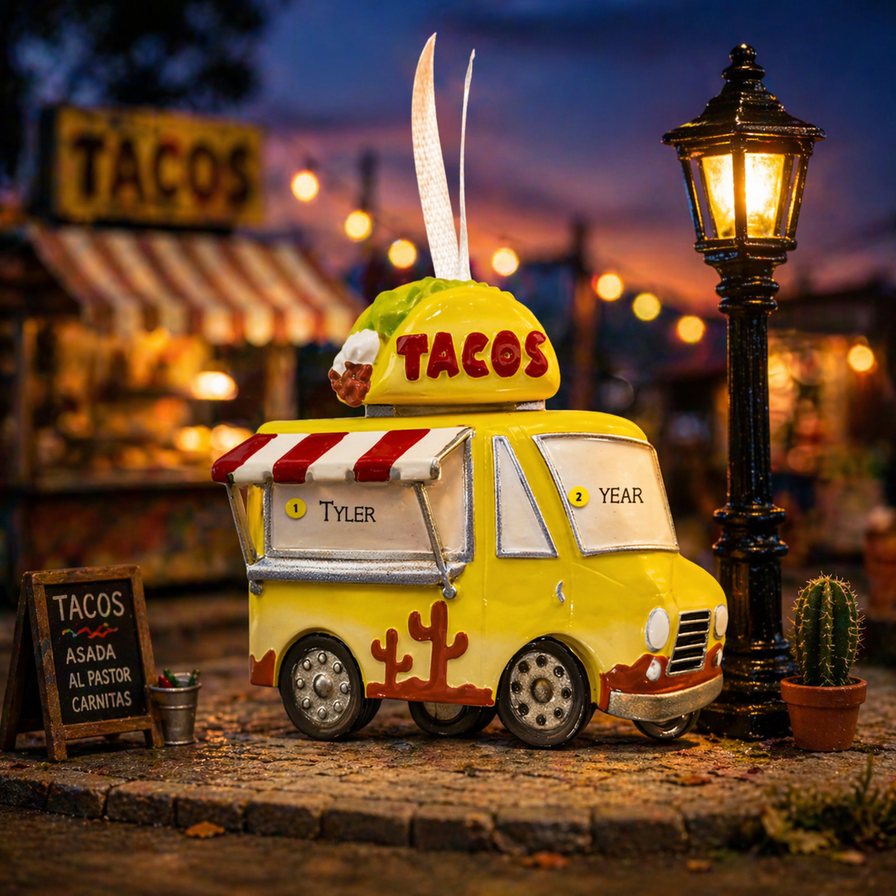 Model of a taco truck ornament with 'custom name' set against a night-time street scene
