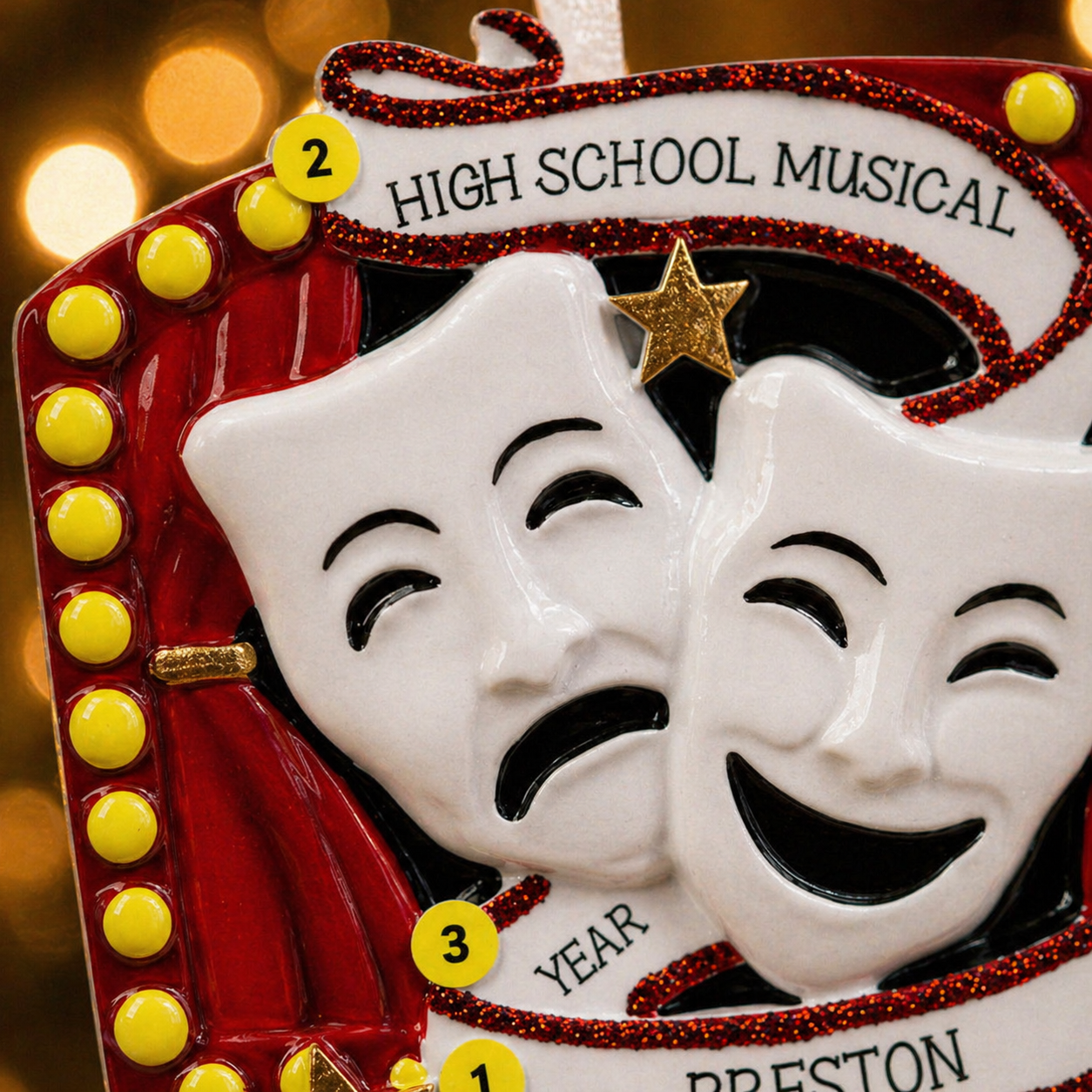 Decorative ornament with theater masks and 'High School Musical' text on a blurred background